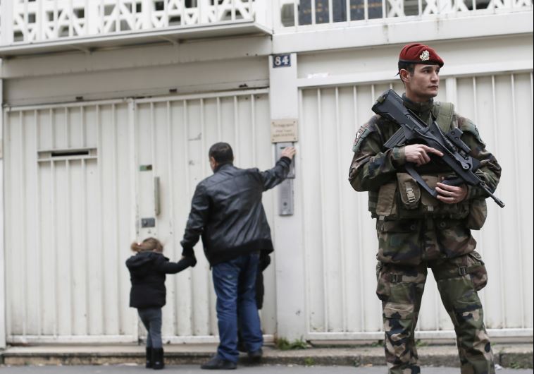 A French soldier secures the entrance to a Jewish school in Paris after the Charlie Hebdo and Hyper Cacher terrorist attacks last January