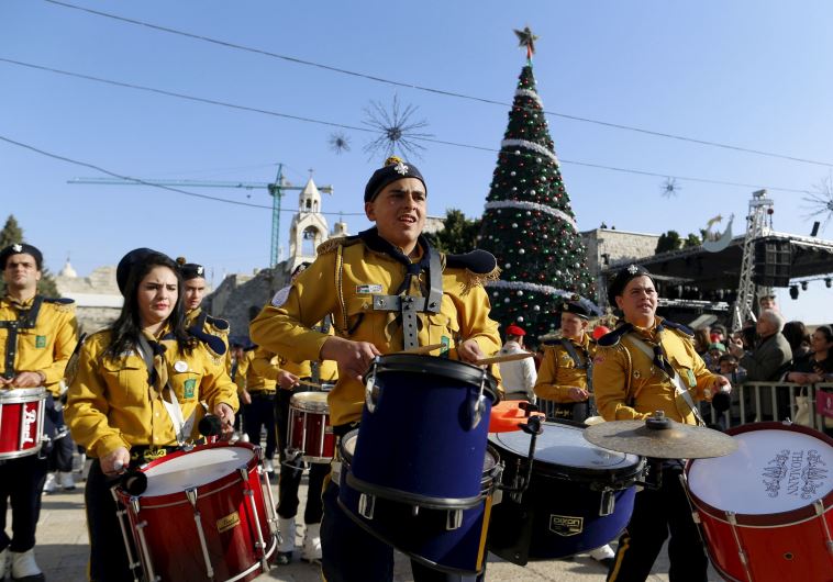 A Palestinian marching band parades during a Christmas procession at Manger Square in the West Bank town of Bethlehem