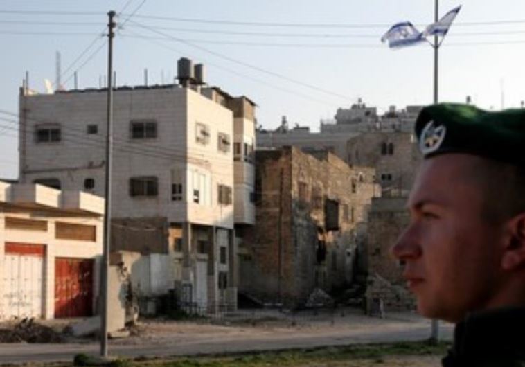 IDF soldier stands guard next to Beit Hamachpela in Hebron.