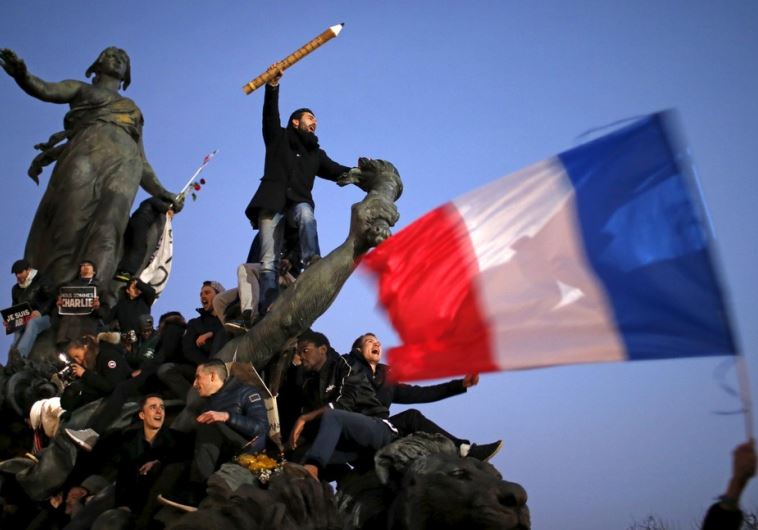 A man holds a giant pencil as he takes part in a solidarity march in the streets of Paris after the Charlie Hebdo shootings