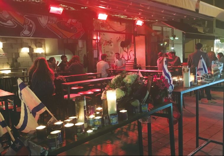 Mourning candles light the entrance to Tel Aviv’s Hasimta Bar on Friday, as it reopened following the previous week’s terrorist attack