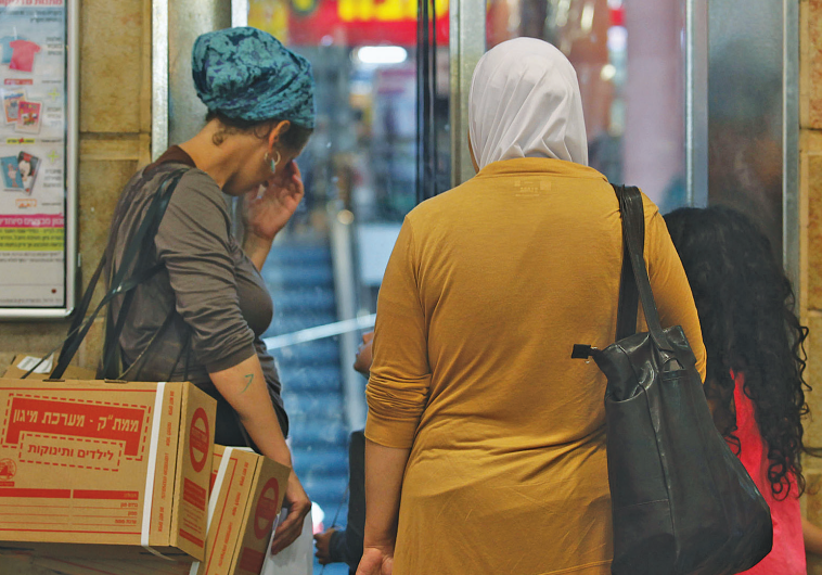JEWISH AND ARAB Israelis wait outside a distribution center to trade in their First Gulf Warera protective gas-mask kits for newer models in 2012.