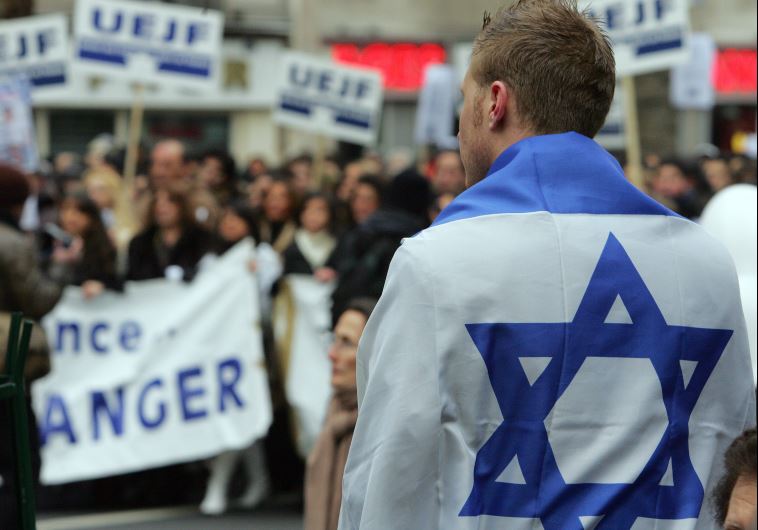 A man with an Israeli flag takes part in a march through Paris