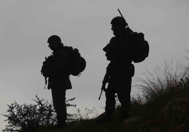 IDF soldiers stand guard during a demonstration by Palestinians against the closure of the main road in Jabaa area south of the West Bank city of Bethlehem