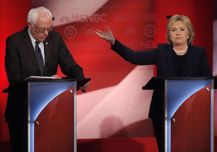 Democratic US presidential candidate and former Secretary of State Hillary Clinton (R) talks about Senator Bernie Sanders (L) during the Democratic presidential candidates debate