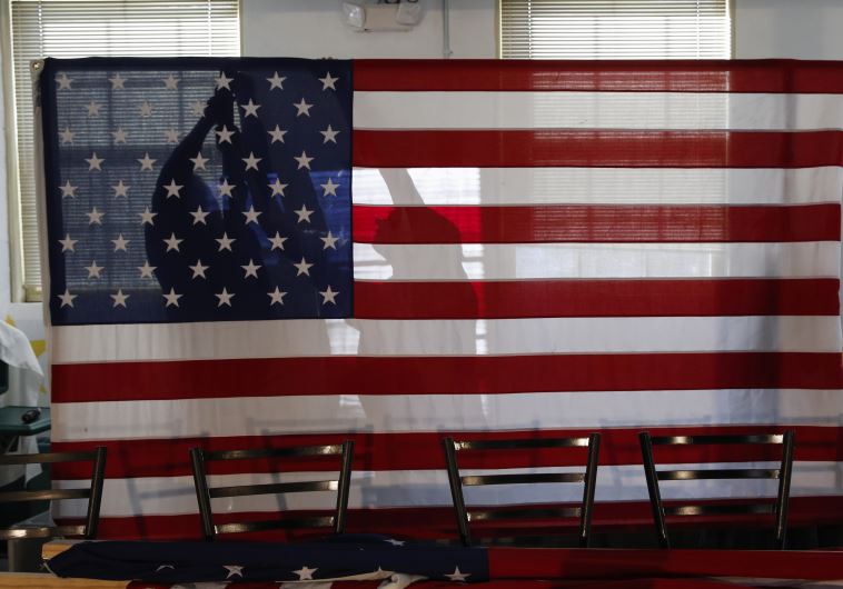 Campaign workers for U.S. Republican presidential candidate and New Jersey Governor Chris Christie put up an American flag before his town hall campaign stop at the Hampton Academy in Hampton, New Hampshire February 7, 2016