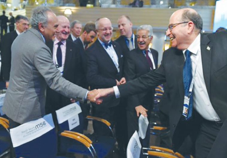 DEFENSE MINISTER Moshe Ya’alon (right) reaches out to Saudi Arabia’s Prince Turki al-Faisal in Munich yesterday.