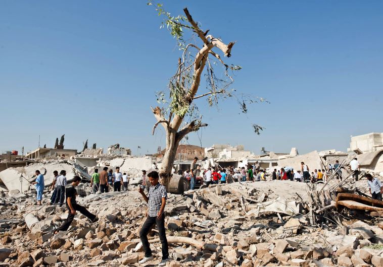 Syrians inspect the scene following an airstrick by regine forces on the town of Azaz, near the northern restive Syrian city of Aleppo, on August 15, 2012. 