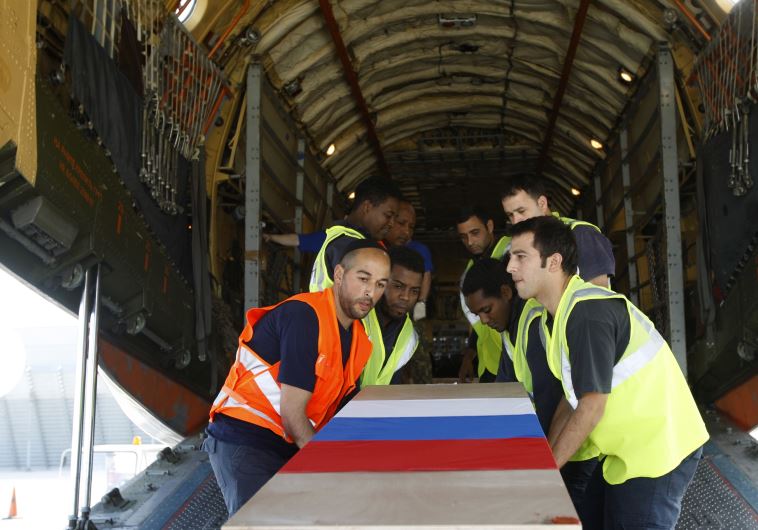 Airport workers carry one of 24 coffins of Russian tour operators, killed in a bus crash north of the Red Sea resort of Eilat, into a Russian airplane at the Ben Gurion International airport near Tel Aviv December 18, 2008.
