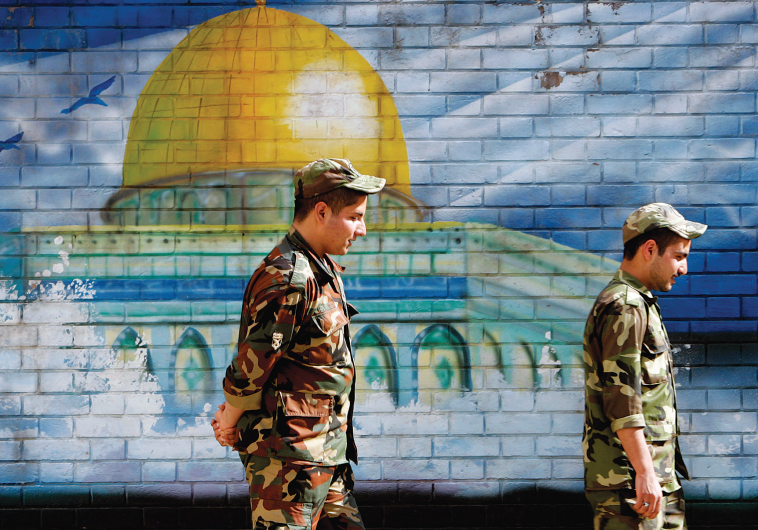 MEMBERS OF Iran’s Revolutionary Guards walk past a mural of the Al-Aqsa mosque in Jerusalem in Tehran.