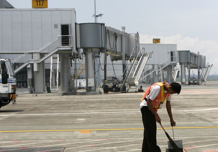 A maintenance worker sweeps the tarmac of Terminal 3 of Ninoy Aquino International Airport