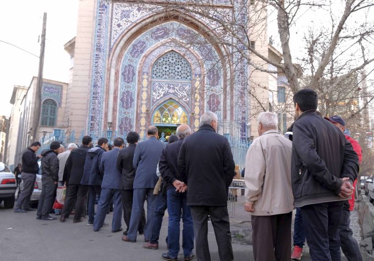 Iranians stand in line to cast their votes during elections for the parliament and Assembly of Experts