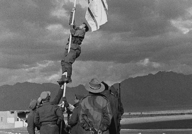 Raising the ink-drawn flag in Eilat. Picture by Micha Perry, an officer in the Negev Brigade, March 10, 1949
