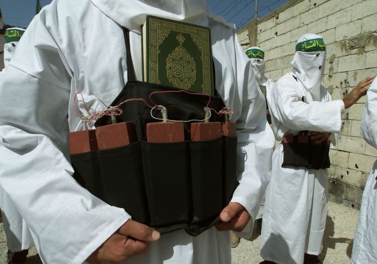 A Palestinian from the Islamic group Hamas carries the holy book the Koran tucked into a belt of simulated explosives