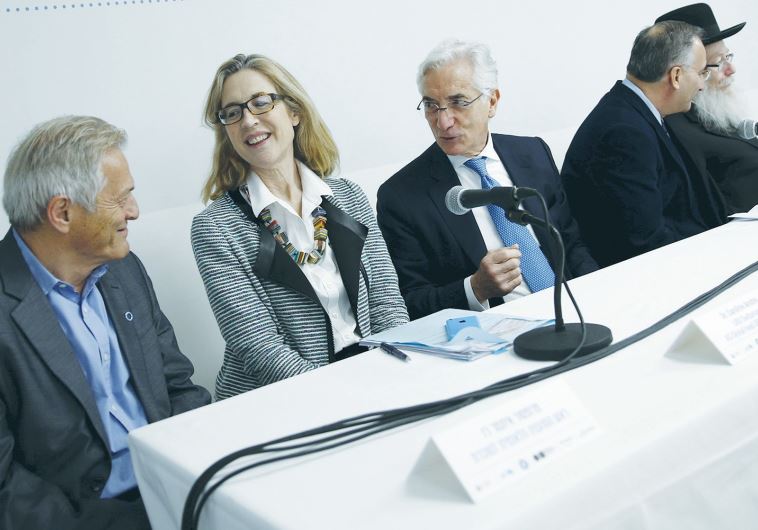 RONALD COHEN (center), the chairman of a global steering group on social-impact investing, sits next to Caroline Anstey, the head of UBS and Society, a global initiative launched by the Swiss investment bank in 2014 that covers activities in sustainable investing and philanthropy, during a news conf