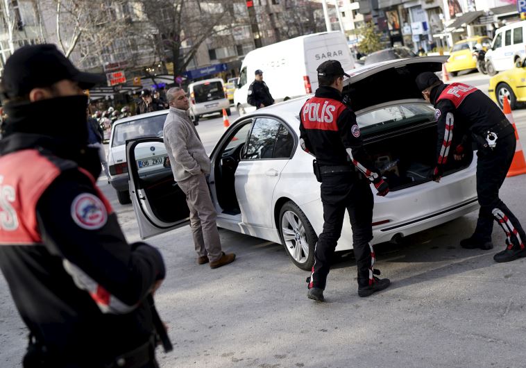 Police officers search a car during a security control check in central Ankara, Turkey March 17.