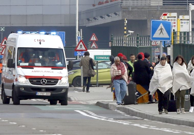  People wrapped in blankets leave the scene of explosions at Zaventem airport near Brussels, Belgium, March 22, 2016. 