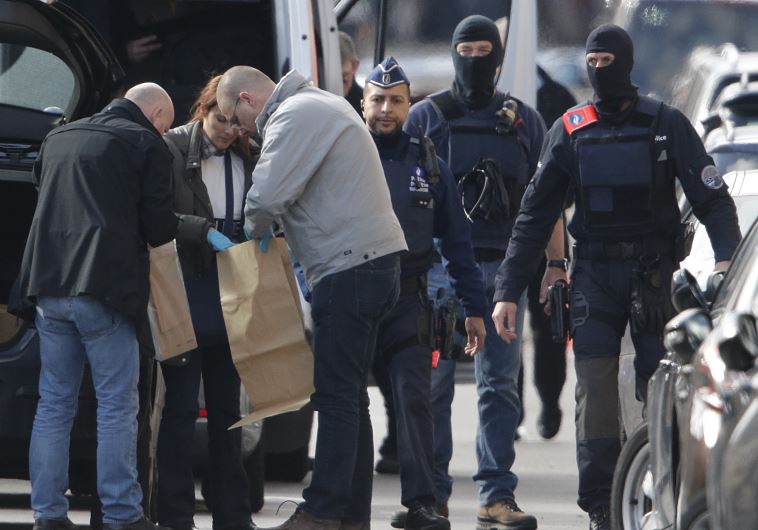 Police look at bags of evidence material during a search in the Brussels borough of Schaerbeek following Tuesday's bombings in Brussels, Belgium, March 25, 2016