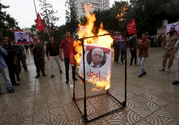 Supporters of the Popular Front for the Liberation of Palestine (PFLP) burn a poster of Palestinian President Mahmoud Abbas during a protest against Abbas's policies, in Gaza City April 12, 2016