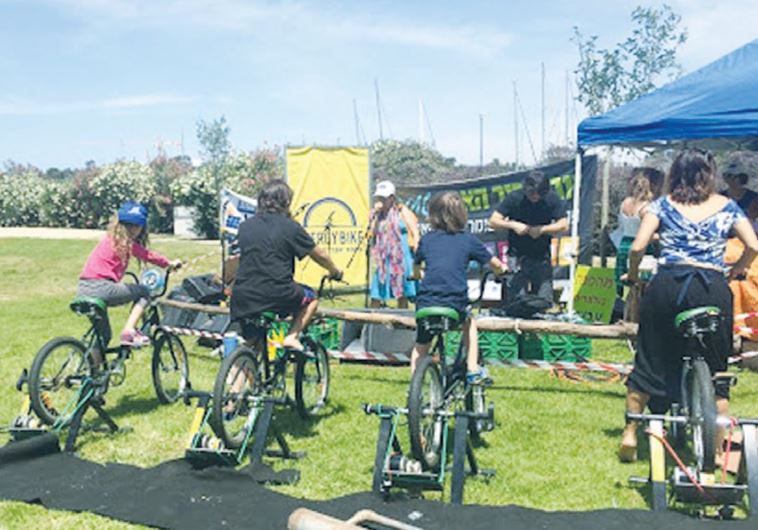 EARTH DAY CELEBRANTS try out electricity-generating bicycles yesterday in Haifa’s Kishon Park.