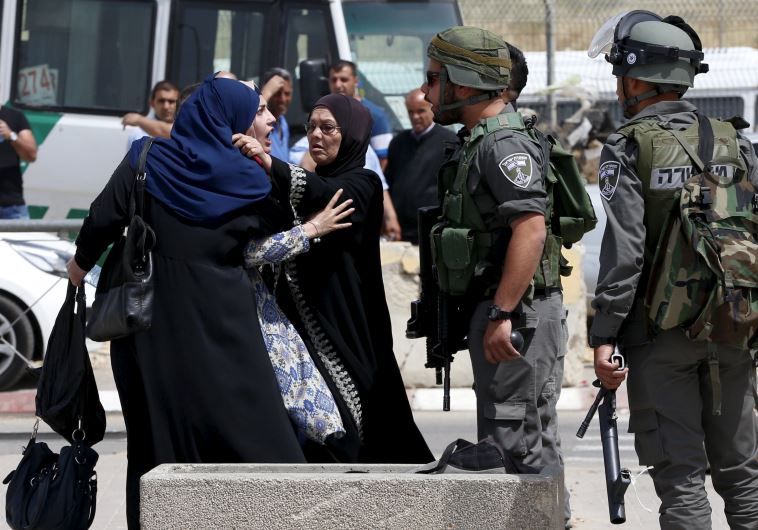 A Palestinian woman argues with border policeman near the scene of attempted stabbing attack at a checkpoint in Kalandiya‏