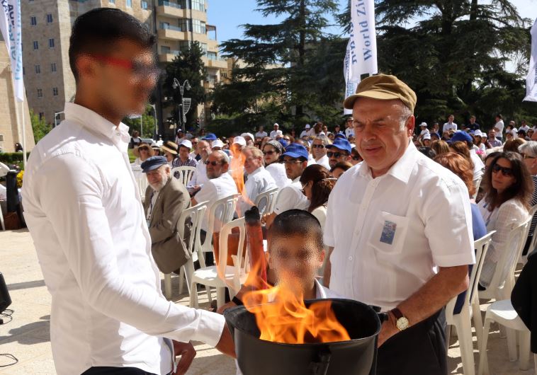 Jewish Agency Chairman Natan Sharansky kindles a memorial flame together with two members of the Nahari family