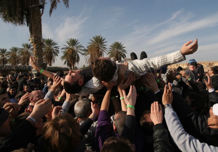 Two men carried  by a cheering crowd