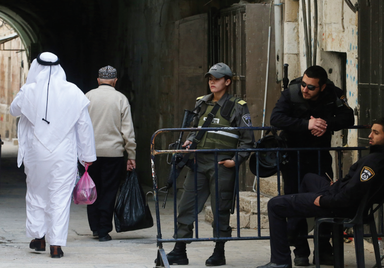 A SPLIT CITY: Two Arab men walk past police officers in the Old City of Jerusalem