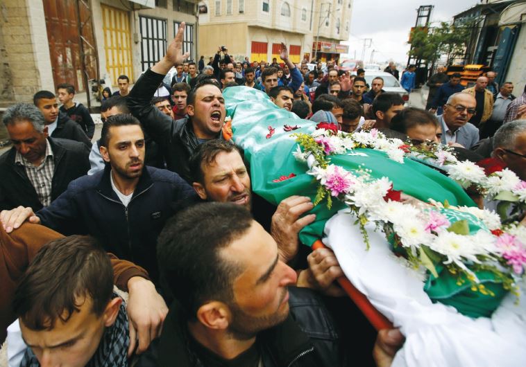Mourners carry the body of Palestinian assailant Abdel Fattah al-Sharif, who was shot and killed after being wounded last March by an Israeli soldier, during his funeral in Hebron on May 28