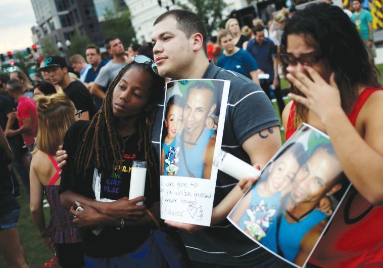 Orlando residents hold a picture of their deceased friend Xavier Emanuel Serrano Rosado during a candlelit vigil in memory of victims of the mass shooting at the Pulse gay nightclub
