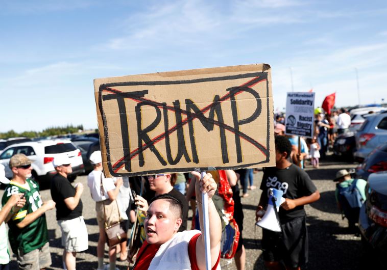 A demonstrator holds a sign against Republican U.S. presidential candidate Donald Trump outside his campaign rally in Sacramento, California