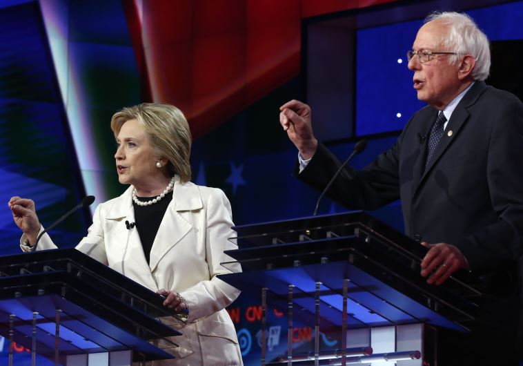 DATE IMPORTED: April 15, 2016 Democratic U.S. presidential candidate Hillary Clinton (L) listens to Senator Bernie Sanders speak during a Democratic debate hosted by CNN and New York One at the Brooklyn Navy Yard in New York April 14, 2016. 
