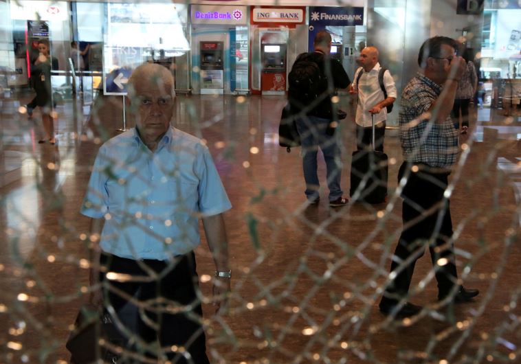 A man looks at a broken glass at Istanbul Ataturk airport, Turkey, following yesterday's blast June 29, 2016.