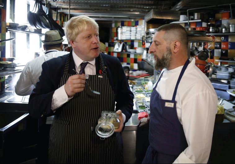 Former London mayor and Brexit champion Boris Johnson stands beside chef Assaf Granit, during a visit to the Machneyuda restaurant in Jerusalem in November