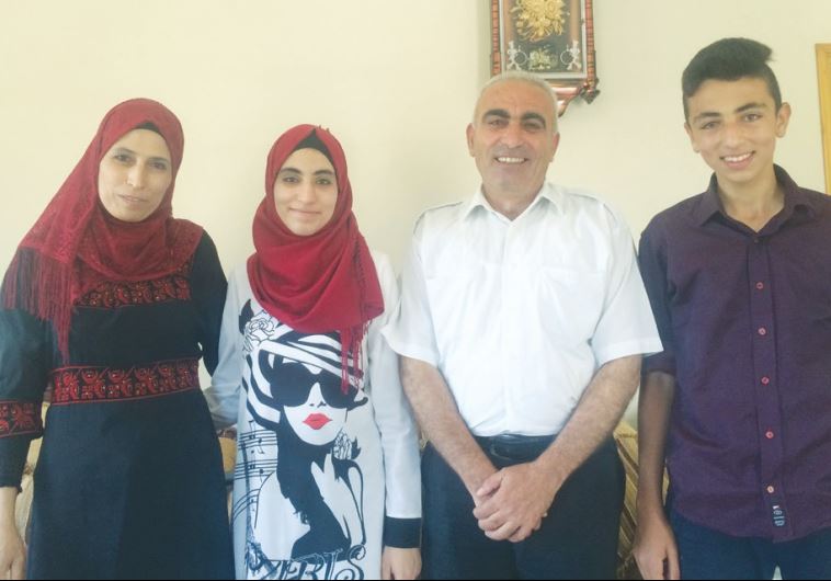RAHAF MUFEED ABDULLAH (second left), who received the highest score on the Palestinian national standardized test, poses for a photo with her family.
