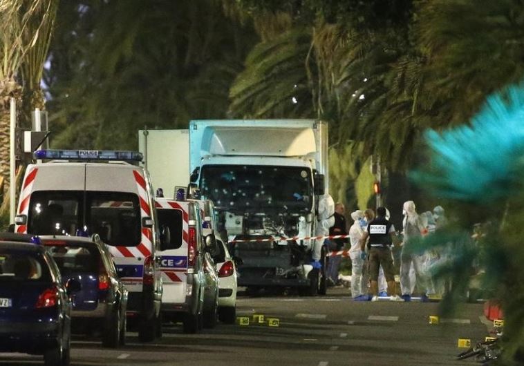 French police forces and forensic officers stand next to a truck July 15, 2016 that ran into a crowd celebrating the Bastille Day national holiday on the Promenade des Anglais killing at least 60 people in Nice, France, July 14. 