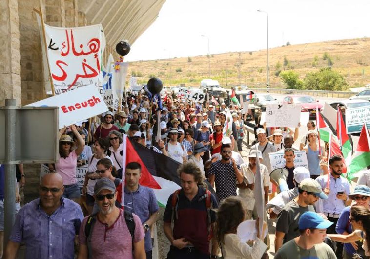 Israelis and Palestinians marching next to the separation barrier on their way to the Tunnels Checkpoint.