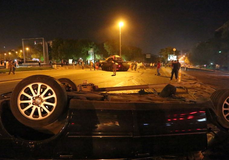A damaged vehicle is seen in front of a military vehicle during an attempted coup in Ankara, Turkey July 16, 2016.