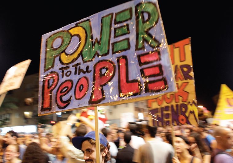 A protester holds a sign during a demonstration in Tel Aviv calling for lower living costs and social justice on September 3, 2011