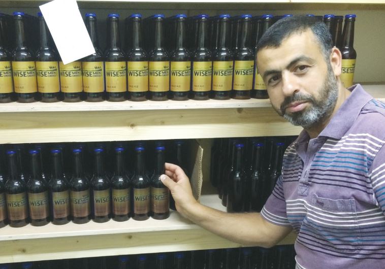 RAFAT HOUARY shows off his Wise Men Choice spiced ales brewed in Beit Sahour.