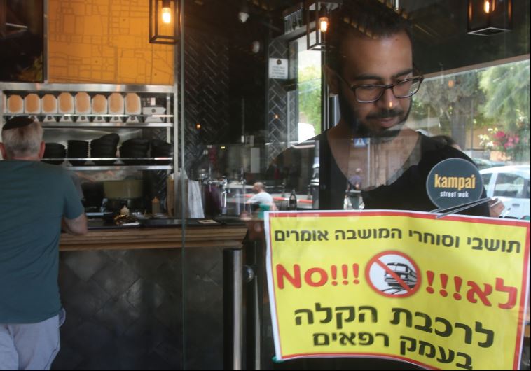 An Emek Refaim eatery owner posts a sign saying ‘No!!!’ to the light rail on the street