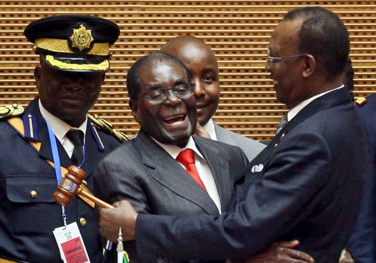 Zimbabwe's President Robert Mugabe (C) talks to Chad's President Idriss Deby (R) after the opening ceremony of the 26th Ordinary Session of the Assembly of the African Union