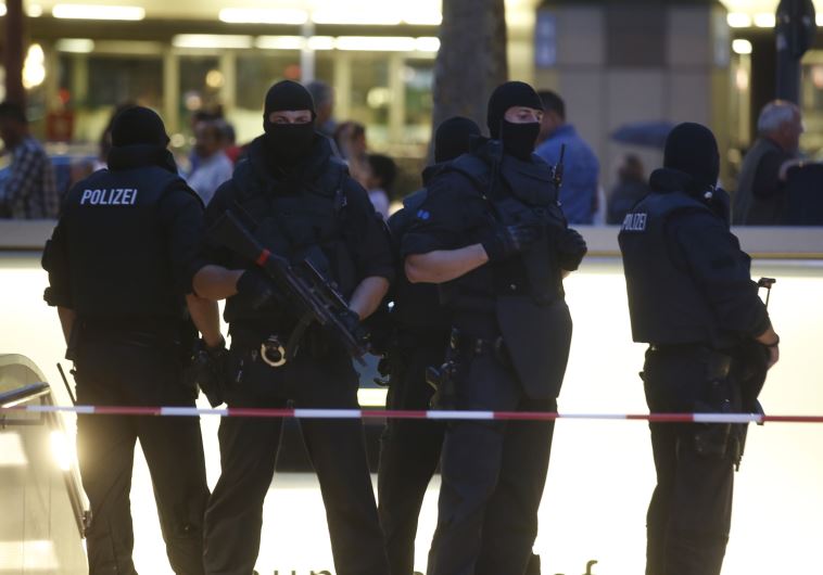 Special force police officers stand guard at an entrance of the main train station, following a shooting rampage at the Olympia shopping mall in Munich