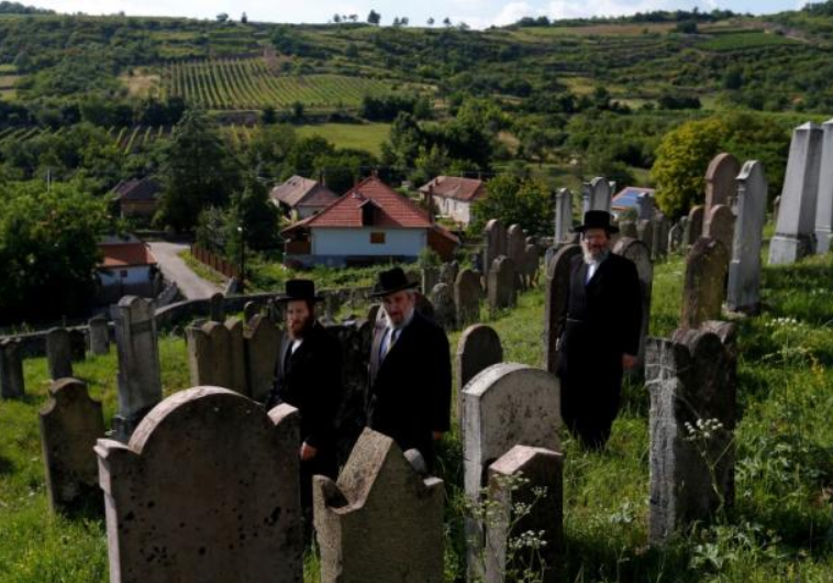  Three rabbis, the sons and grandson of a leading Hasidic rabbi Eliezer Ehrenreich walk in the cemetery in the village of Mad, Hungary, July 21, 2016. Picture taken July 21, 2016