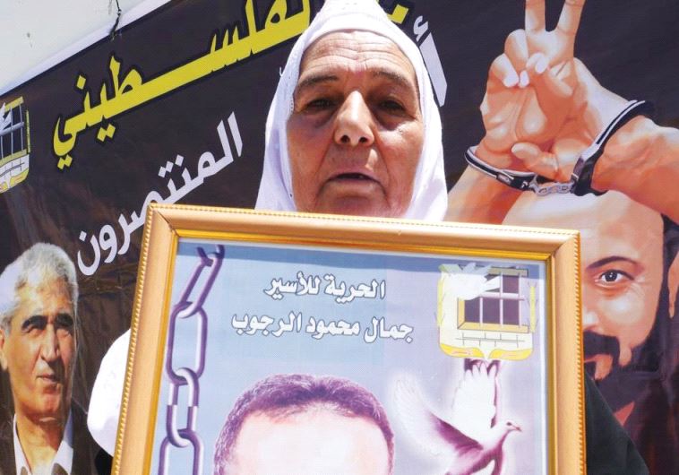 YASMIN RAJOUB displays a photo of her son, Jamal, who is serving a life sentence for terrorism at Rimon Prison. (