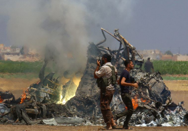 Men inspect the wreckage of a Russian helicopter that had been shot down in the north of Syria's rebel-held Idlib province, Syria August 1, 2016