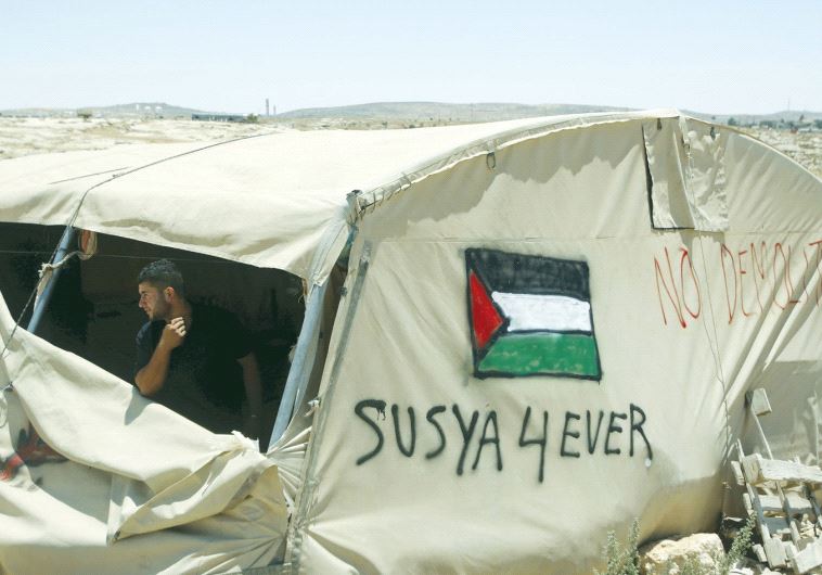 A PALESTINIAN man looks out from his tent in Susiya village near Hebron in July of 2015.