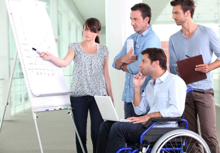 A woman and three men look at a chart