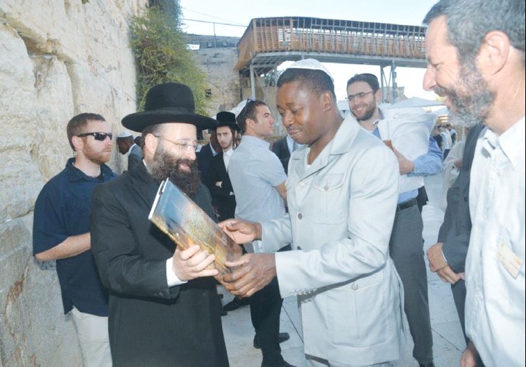 TOGO PRESIDENT Faure Gnassingbe receives a book from Rabbi Shmuel Rabinowitz during a visit to the Western Wall yesterday.