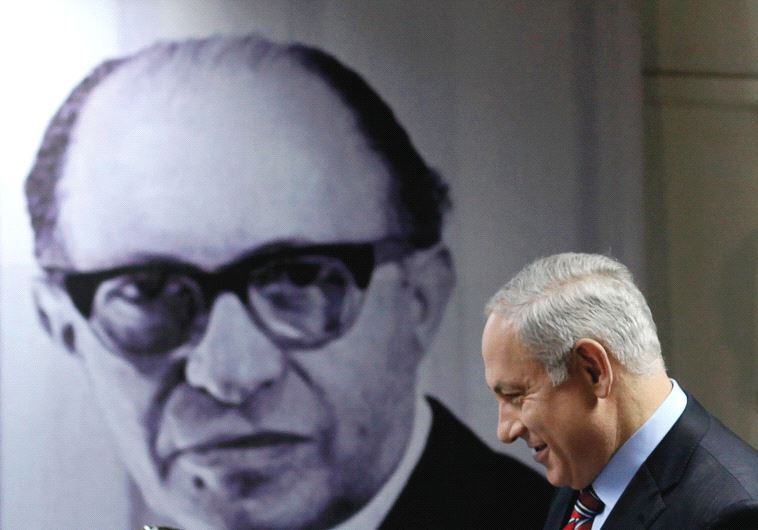 PRIME MINISTER Benjamin Netanyahu walks in front of a poster depicting the late prime minister Menachem Begin, upon his arrival at the Likud party’s headquarters in Tel Aviv in 2010